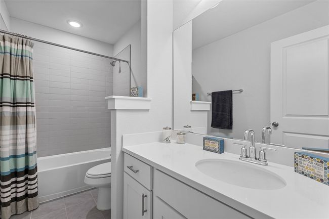 Full bathroom featuring vanity, toilet, tile patterned floors, shower / tub combo with curtain, and recessed lighting | Image 30