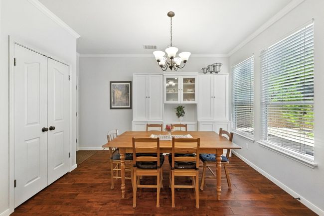 Dining space with a chandelier, ornamental molding, and dark wood-type flooring | Image 10