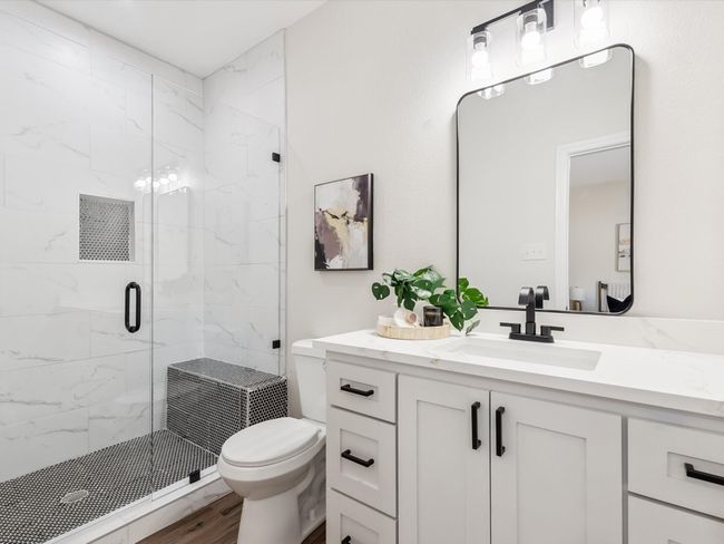 Bathroom with wood finished floors, toilet, vanity, and a marble finish shower | Image 14