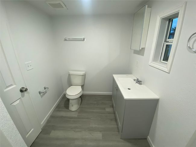 Half bath featuring toilet, wood finished floors, vanity, and baseboards | Image 12