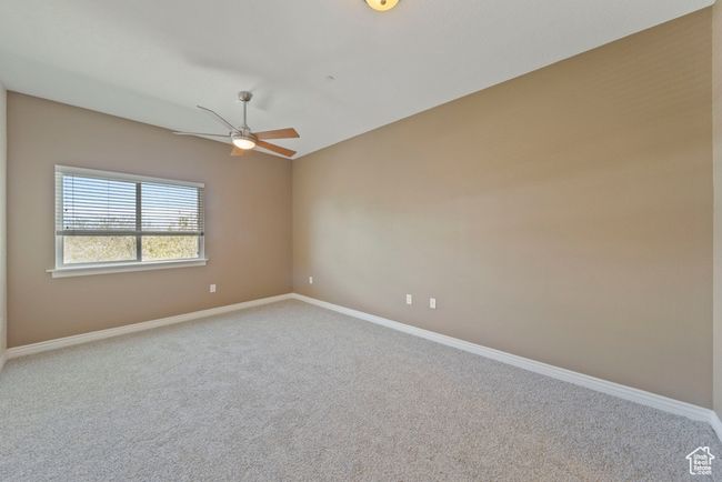 Carpeted empty room featuring a ceiling fan and baseboards | Image 8