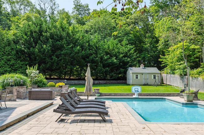 View of swimming pool featuring a patio and an outbuilding | Image 43