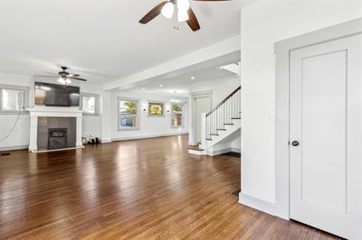 Unfurnished living room with ceiling fan, a tile fireplace, and dark hardwood / wood-style floors | Image 3