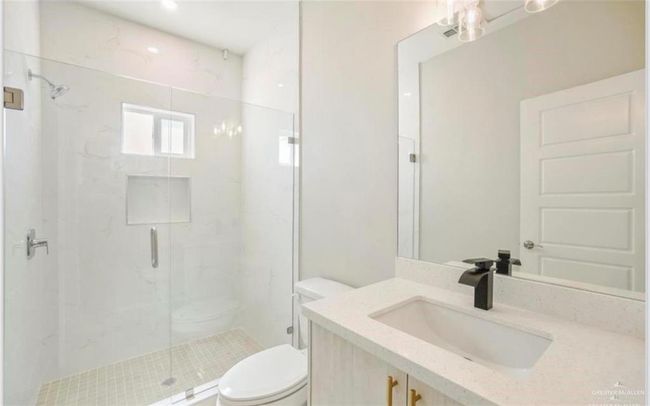 Bathroom featuring vanity, toilet, and a shower with door | Image 7