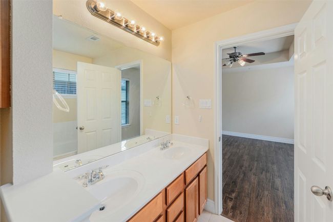Full bathroom with ceiling fan, double vanity, and wood finished floors | Image 18