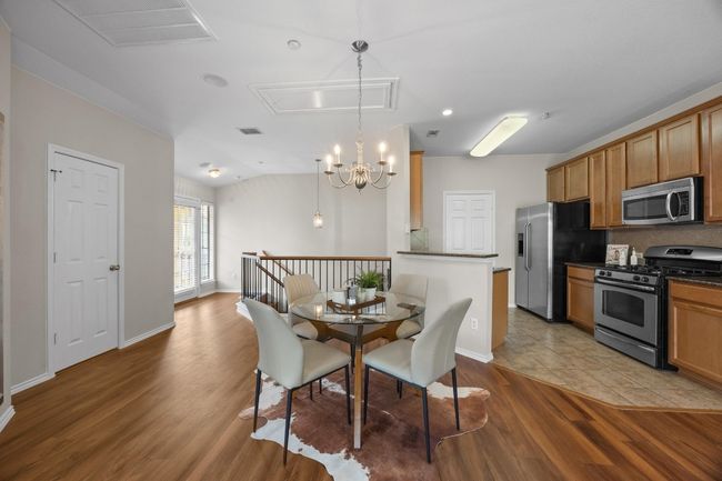 Dining area featuring vinyl wood flooring, and chandelier | Image 16