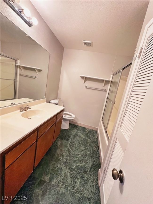 Bathroom with vanity, toilet, shower / bath combination with glass door, and a textured ceiling | Image 8