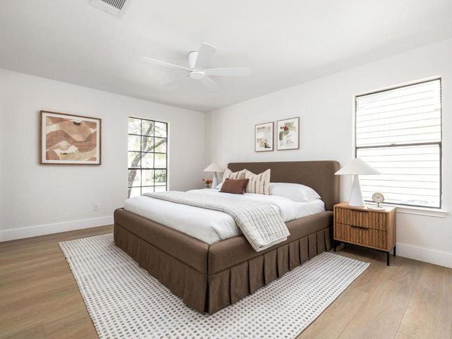 Bedroom with light wood-style flooring, baseboards, ceiling fan, and visible vents | Image 6