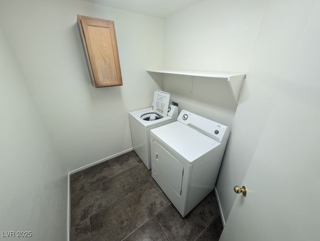 Laundry area with stone finish flooring, separate washer and dryer, and cabinet space | Image 19