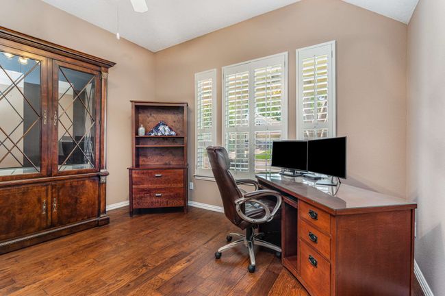 Office space featuring wood finished floors, baseboards, and ceiling fan | Image 10