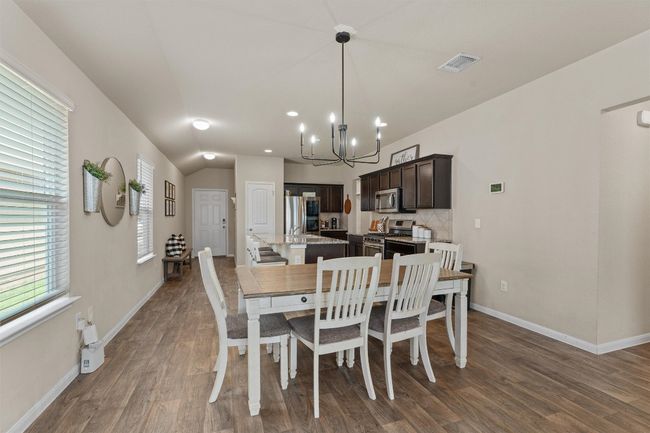 Dining area with a chandelier and dark wood finished floors | Image 10