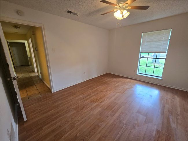 Spare room with wood finished floors, a textured ceiling, a ceiling fan, and a smoke detector | Image 16