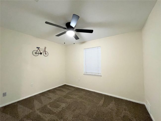 Empty room with dark carpet and ceiling fan | Image 24