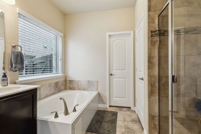 Bathroom featuring a shower stall, a garden tub, and vanity | Image 17