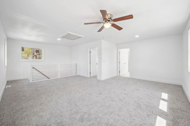 Carpeted empty room with visible vents, baseboards, a ceiling fan, and recessed lighting | Image 21