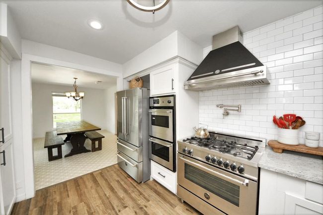 Outfitted with Bertazzoni appliances—including gas range, pot filler, hood, dishwasher, and fridge that stays—plus three ovens for ultimate cooking versatility. | Image 11