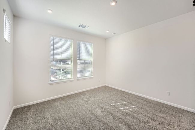 Spare room featuring baseboards, visible vents, carpet floors, and a healthy amount of sunlight | Image 16