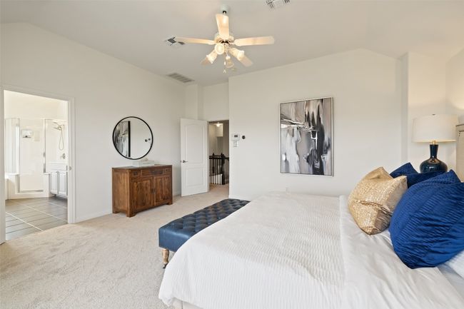 Carpeted bedroom with ceiling fan, tile patterned floors, vaulted ceiling, and ensuite bathroom | Image 26