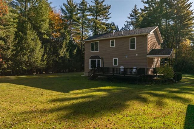 Rear view of property featuring a wooden deck and a yard | Image 31