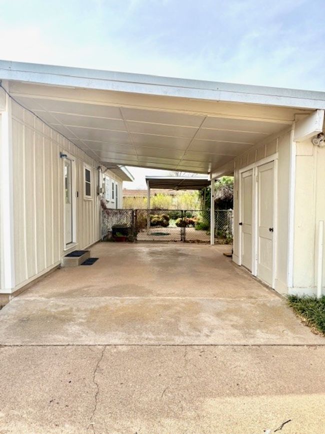View of parking / parking lot with fence and a carport | Image 5
