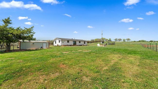 View of yard with a rural view, fence, and an outbuilding | Image 8