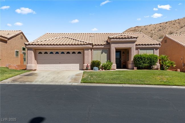 View of front of home featuring a garage, a front lawn, concrete driveway, stucco siding, and a tiled roof | Image 50
