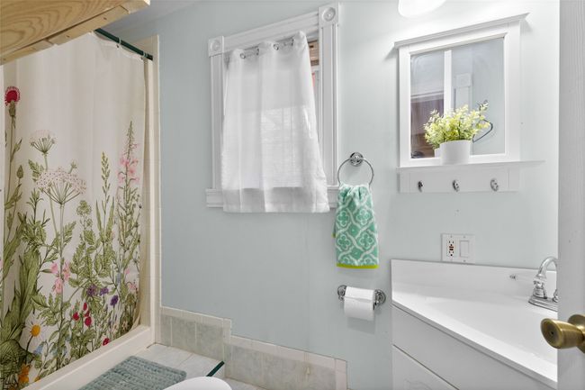 Bathroom with a shower, tile patterned flooring, and vanity | Image 23