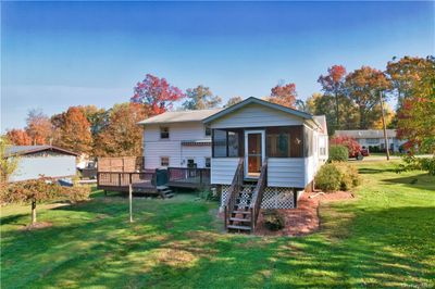 Rear view of house with a wooden deck and a lawn | Image 3