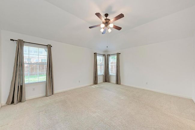 Unfurnished room featuring light carpet, ceiling fan, baseboards, and lofted ceiling | Image 22