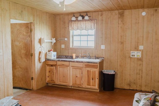Bathroom featuring wood walls, concrete flooring, vanity, wooden ceiling, and ceiling fan | Image 25