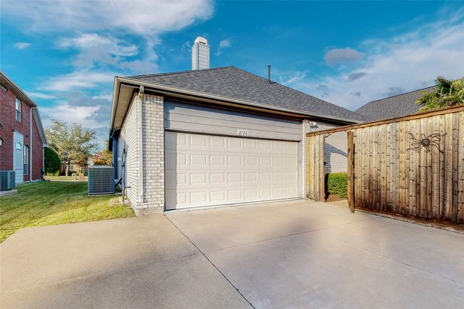 Garage featuring concrete driveway and central AC | Image 40