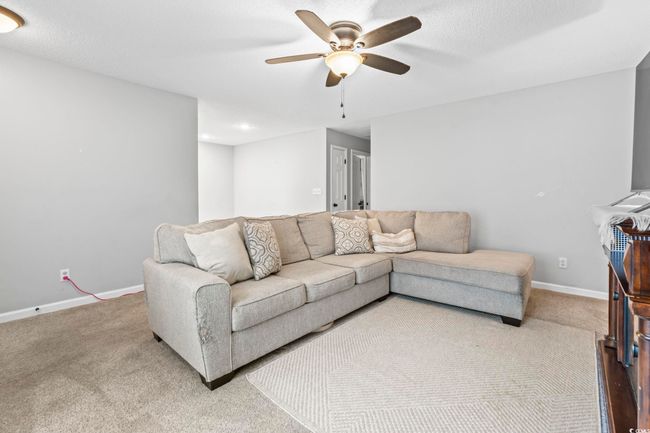 Living area featuring a ceiling fan and carpet floors | Image 5