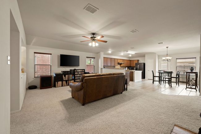 Warm tile fireplace and built-in niche for aquarium or décor add charm to the living space. View extends to the dining area with access to the backyard. | Image 12