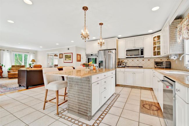 Kitchen featuring a sink, stainless steel appliances, light tile patterned floors, decorative backsplash, and recessed lighting | Image 17