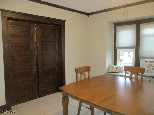 Dining room with light tile patterned floors and crown molding | Image 17
