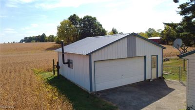 Garage featuring wooden walls and a rural view | Image 3