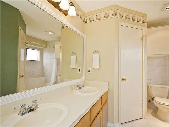 Full bath featuring tile patterned floors, toilet, a shower with shower curtain, and a sink | Image 9