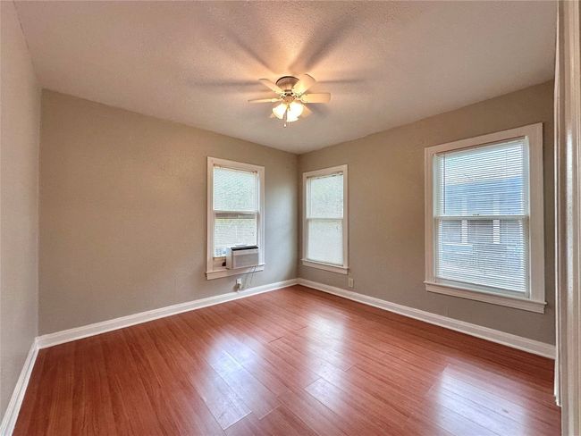 Unfurnished room with wood finished floors, ceiling fan, and cooling unit | Image 15