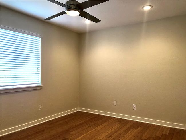Empty room with dark wood-style floors, a ceiling fan, and recessed lighting | Image 8