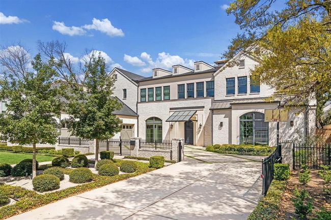 A luxurious Oak Estates home, this property showcases impeccable designer finishes throughout. The striking exterior blends brick, stone, and stucco, highlighted by elegant bronze lanterns and exceptional craftsmanship. A private drive leads to a beautifully gated motor court, revealing a spacious three-car garage. | Image 36