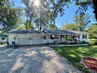 Ranch-style house featuring a porch, a garage, and a front yard | Image 2