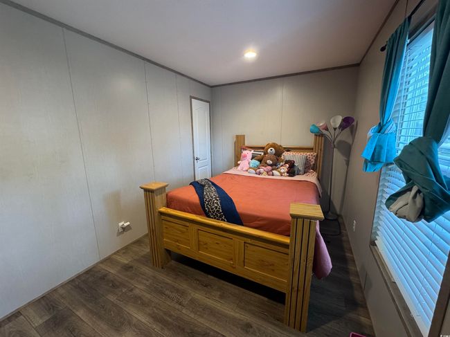 Bedroom with dark wood finished floors and a decorative wall | Image 16