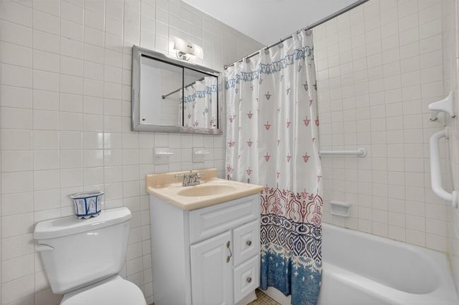 Full bath featuring tile walls, vanity, and shower / bathtub combination with curtain | Image 30