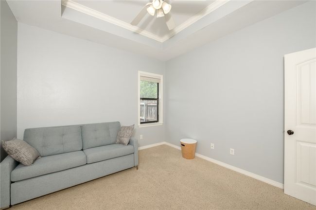 Sitting room featuring a raised ceiling, baseboards, ornamental molding, carpet, and a ceiling fan | Image 24
