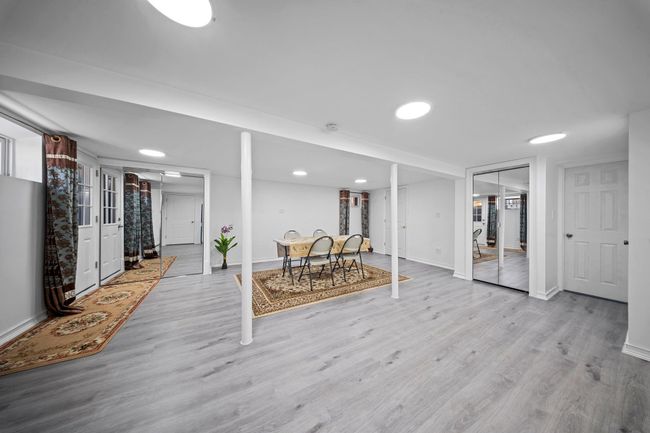 Finished basement with baseboards and wood finished floors | Image 22