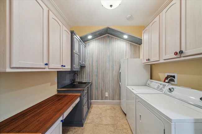 A WALL OF CUSTOM BEADBOARD LINES THE BACK WALL ADDING TEXTURE TO THIS SPACIOUS UTILITY ROOM. INCLUDED ARE THE FREEZER, WASHER, DRYER. CUSTOM CABINETS FEATURE THIS FUN HARDWARE, A BUILT-IN SINK AND GORGEOUS ONE-OF-A KIND FOLDING TABLE | Image 42