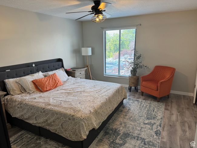 Bedroom featuring wood finished floors, a textured ceiling, and ceiling fan | Image 17