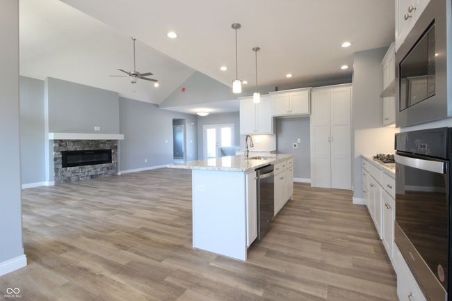 kitchen featuring a sink, ceiling fan, white cabinetry, stainless steel appliances, and lofted ceiling | Image 5