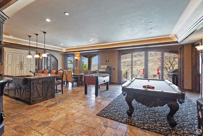 Recreation room with a tray ceiling, pool table, recessed lighting, and stone tile flooring | Image 47
