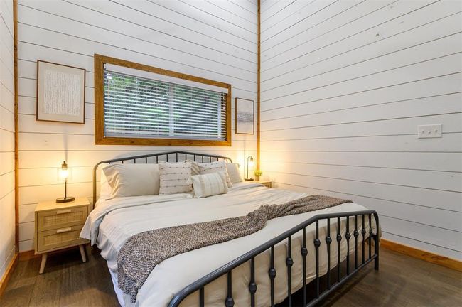 Bedroom featuring wood walls and dark hardwood / wood-style floors | Image 26